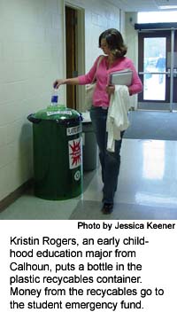 Kristin Rogers, an early childhood education major from Calhoun, puts a bottle in the plastic recycables container.  Money from the recycables go to the student emergency fund.