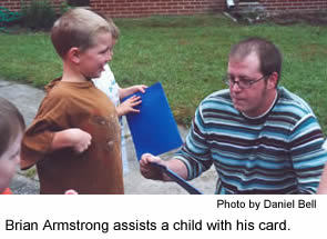 Brian Armstrong assists a child with his card