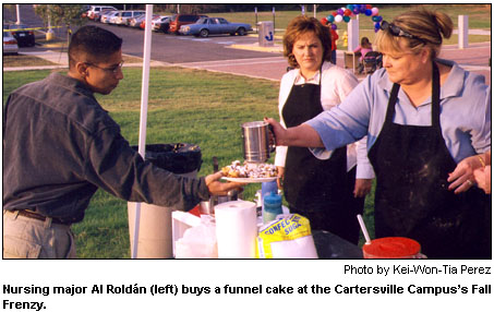 Nursing major Al Roldn (left) buys a funnel cake at the Cartersville Campuss Fall Frenzy.