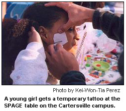 A young girl gets a temporary tattoo at the SPAGE table on the Cartersville campus.