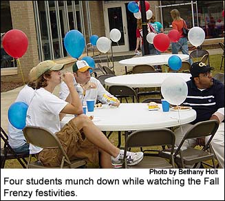 Four students munch down while watching the Fall Frenzy festivities.