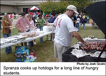 Spranza cooks up hotdogs for a long line of hungry students.