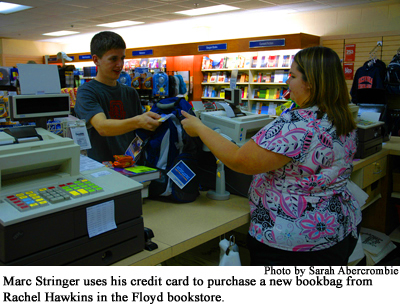 Marc Stringer uses his credit card to purchase a new bookbag from Rachel Hawkins in the Floyd bookstore 
