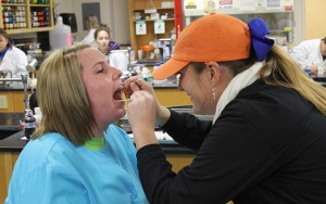 Brandi Ann Hughes tests classmate Cortney McMahan for strep throat in their Introduction to Microbiology lab. Photo by Ryan Jones.