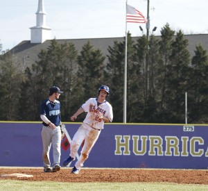 Gavin Peters heads to third base, passing Cleveland State's infielder and helping start the Chargers' inaugural season. Photo by Antonio Garcia