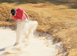 John Chandler, captain of the new GHC golf team swings his way out of a sand trap. Photo by Tatiana Smithson.