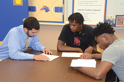 (From left) Matt Williams goes over information with prospective recruits Deontae Woodbridge and Shakari Jones, both from Arkansas. Photo by Karlee Helms.