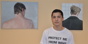 Luis Valencia stands with two of his paintings (from left) “Noah” and “In Grid.” More of his artwork is featured in the Old Red Kimono. Photo by Anna Douglass.