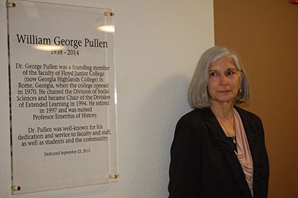 George Pullens wife, Ann Pullen, stands next to plaque honoring her late husband.