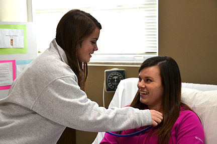Students Brooke Scott (left) and Joanna Mullenax practice their skills in the nursing lab. Photo by Cassandra Humphries