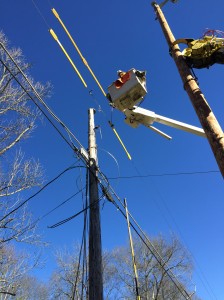 Calen cooper uses a boom lift to fix power lines.  Photo by LaTonya