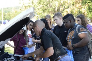 Bryce Wood of Jim’s Tires demonstrates to GHC students how to locate the car battery and attach jumper cables. Photo by Xavier Freeman 