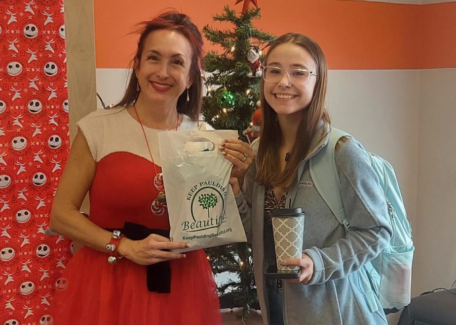 Alexandra Reiter presents Angelena Gienapp with a gift bag from Keep Paulding Beautiful after filling two buckets of trash from the courtyard and neighboring areas.