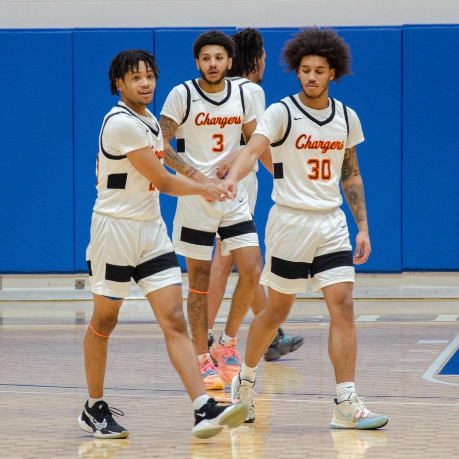 Chargers players Kyree Mitchell-Hairston (20), Joel Pullen (30) and Chris Wright focus in after a basket by the Chargers.