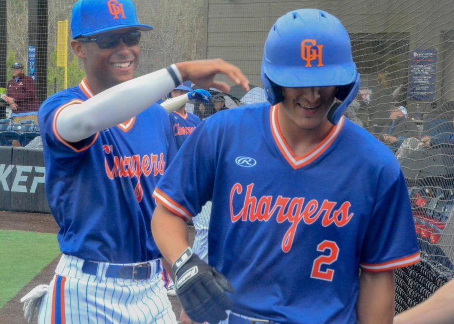 Chargers players celebrate with teammate Austin Tienda after he scores a run in their game against Cleveland State Community College on March 17, 2022.