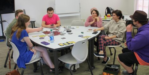 Members of the Gaming Club, including President Tristen Tolbert and Co-Advisor Victoria Banks, gather in the Paulding campus Learning Commons to play board games and partake in pizza for a club event called Game Lounge. Members are taking their turns in Betrayal at House on the Hill.