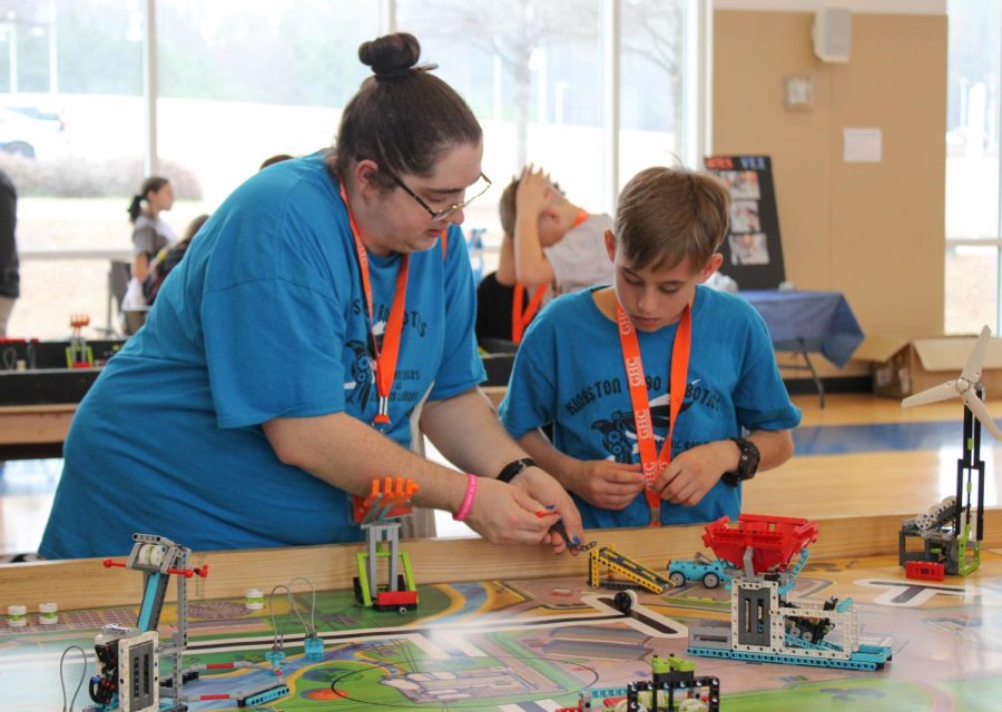 Kingston+Elementary+robotics+team+Electric+Eagles+coach%2C+Stephanie+Skiffen+%28left%29%2C+works+with+team+member+Ian+Walker+%28right%29+on+one+of+the+practice+tables+available+to+all+teams.