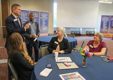A Cartersville-Bartow Chamber of Commerce member and GHC representatives, such as President Mike Hobbs (standing, far left), have a casual discussion after the roundtable ended.